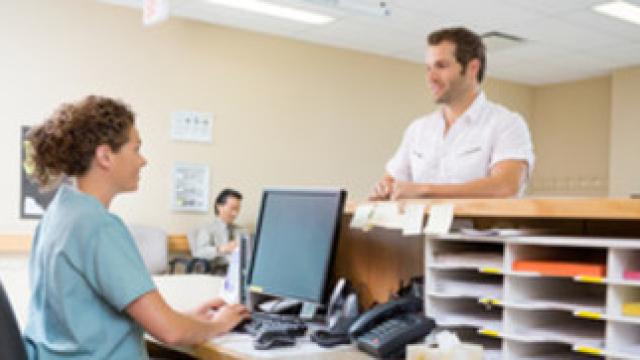 GP receptionist registering a patient